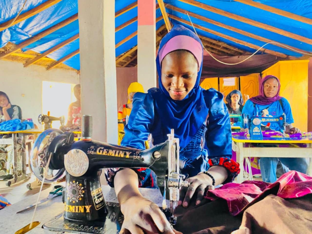 Young woman creating a bogolan stencil design